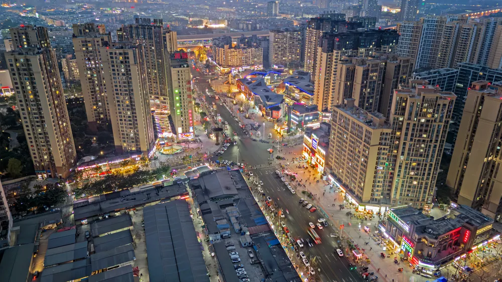 俯瞰夜色中的商业区，高楼与灯火交织成城市街道