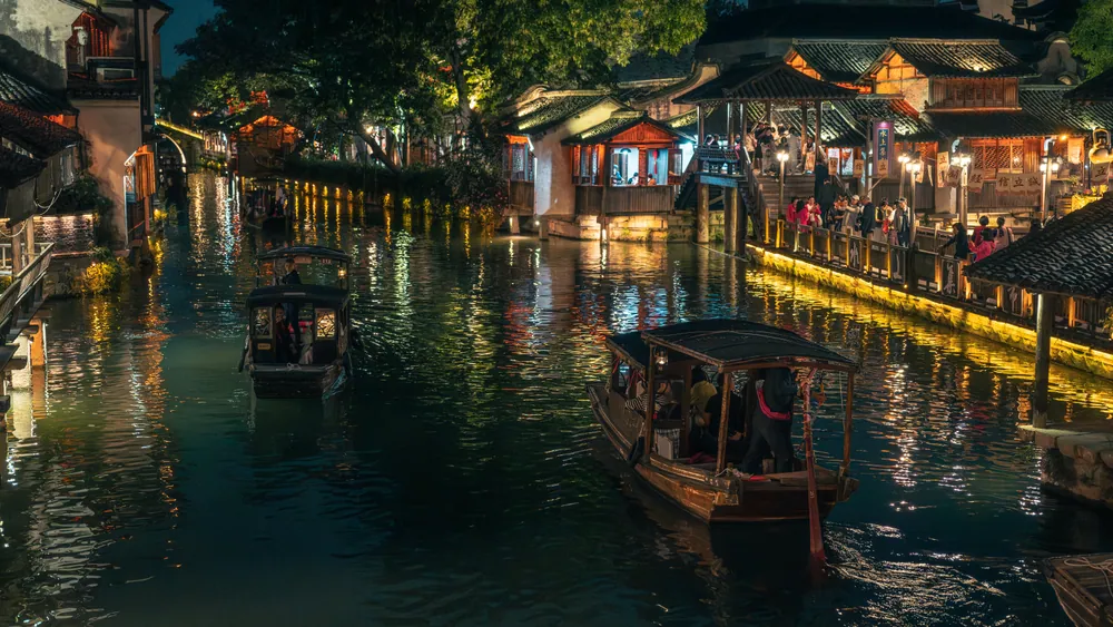 乌镇水巷夜景，灯火、游船与沿岸的人群